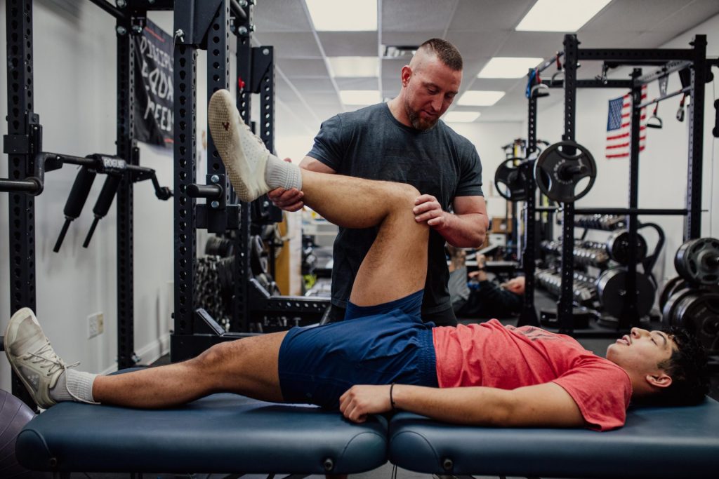 young male athlete working with personal trainer